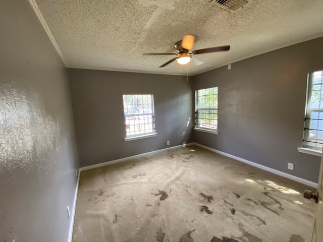 spare room with a textured ceiling, carpet flooring, and ceiling fan