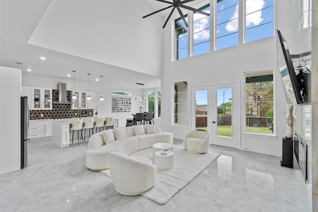 living room featuring french doors, a notable chandelier, and a high ceiling