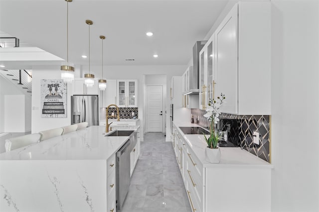 kitchen featuring pendant lighting, backsplash, stainless steel appliances, and white cabinetry