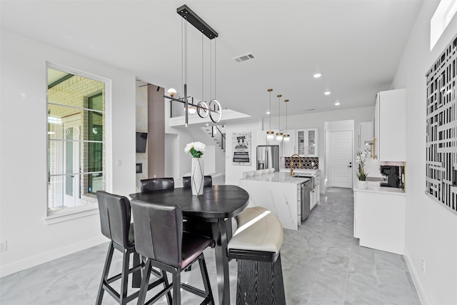 dining area with a chandelier, a wealth of natural light, and sink