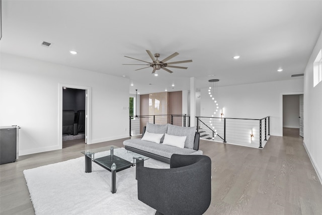 living room with light wood-type flooring and ceiling fan