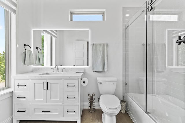 full bathroom with vanity, hardwood / wood-style flooring, toilet, and enclosed tub / shower combo