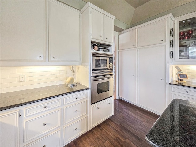 kitchen with white cabinets, lofted ceiling, tasteful backsplash, appliances with stainless steel finishes, and dark hardwood / wood-style floors