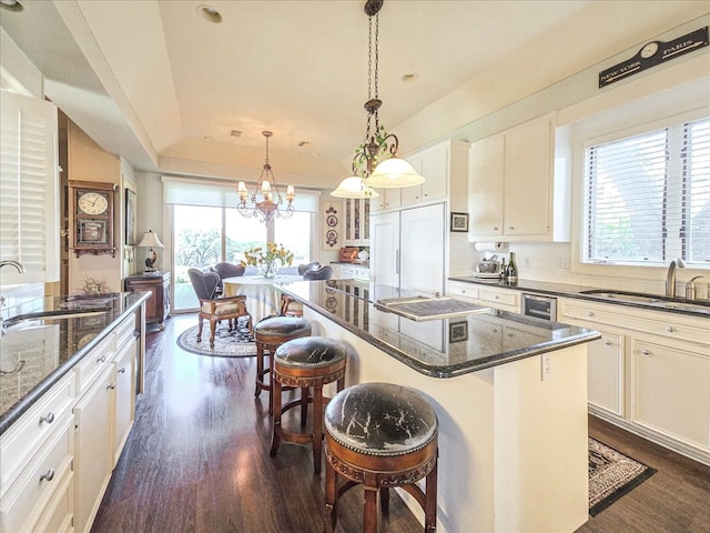 kitchen with paneled built in refrigerator, a center island, a kitchen bar, and plenty of natural light