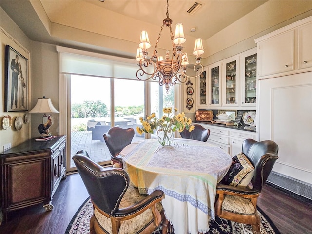 dining area featuring dark hardwood / wood-style floors and a chandelier