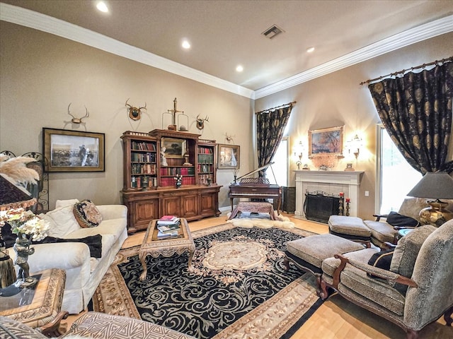 living room with hardwood / wood-style floors, ornamental molding, and a tiled fireplace