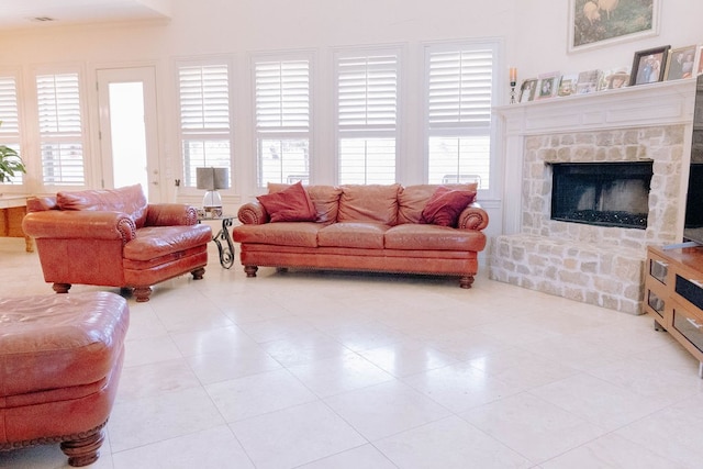 living room with a fireplace, light tile patterned floors, and plenty of natural light