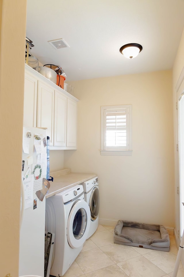 laundry area with cabinets, washing machine and clothes dryer, and light tile patterned floors