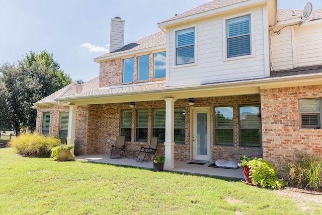 back of house featuring ceiling fan, a patio, and a lawn