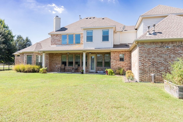 rear view of property with a patio and a yard