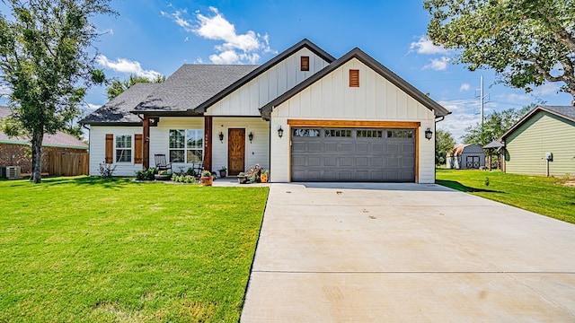 view of front of property featuring a garage, a front lawn, and central AC