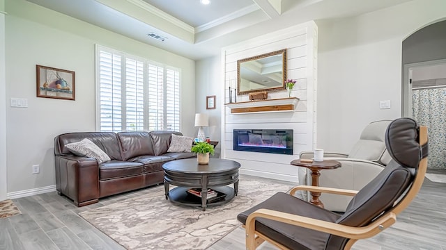 living room with ornamental molding, light wood-type flooring, coffered ceiling, and a large fireplace