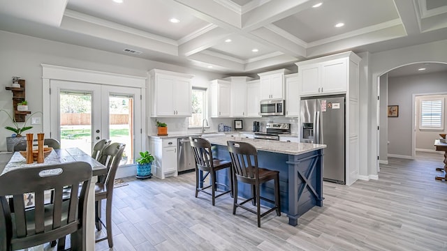 kitchen with white cabinetry, light hardwood / wood-style flooring, stainless steel appliances, and a wealth of natural light