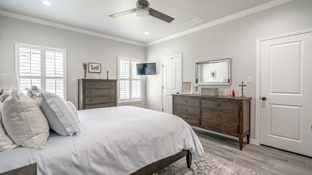 bedroom featuring multiple windows, crown molding, light hardwood / wood-style floors, and ceiling fan