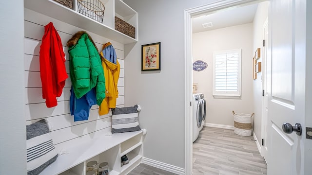 mudroom with light hardwood / wood-style floors and washer and dryer