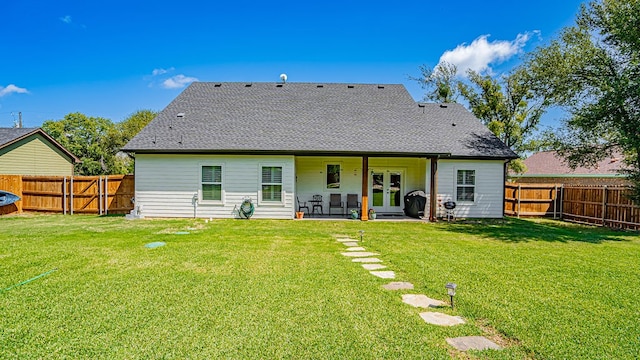 rear view of house featuring a lawn and a patio