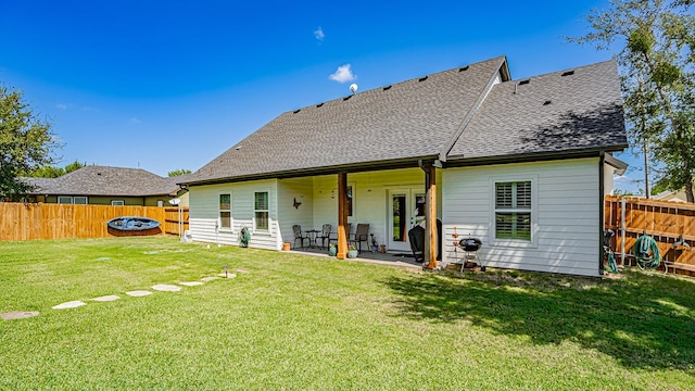 back of property with a yard and a patio area