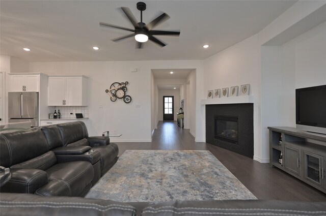 living room featuring dark wood-type flooring and ceiling fan