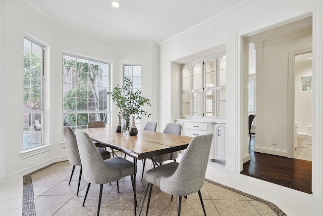 dining space with ornamental molding and light tile patterned flooring