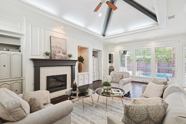 living room with vaulted ceiling, a brick fireplace, ceiling fan, hardwood / wood-style flooring, and ornamental molding