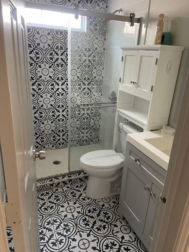 bathroom with toilet, vanity, tile patterned floors, and an enclosed shower