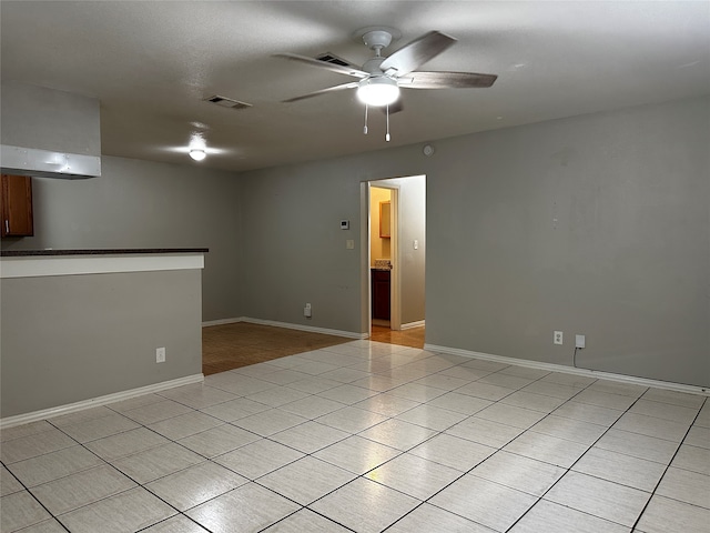 tiled empty room featuring ceiling fan