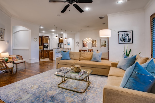 living room with ceiling fan with notable chandelier, crown molding, and dark hardwood / wood-style floors