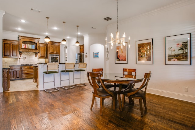 dining area with an inviting chandelier, ornamental molding, and dark hardwood / wood-style flooring