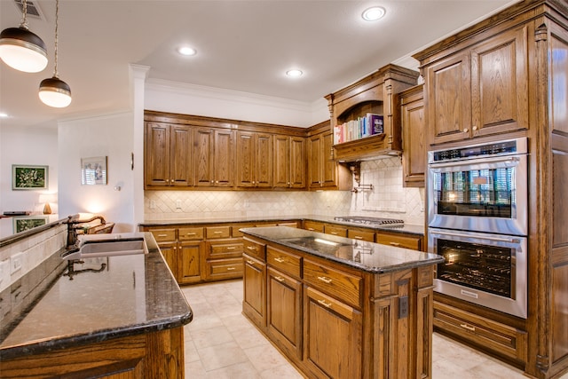 kitchen featuring dark stone counters, sink, a kitchen island, appliances with stainless steel finishes, and decorative light fixtures