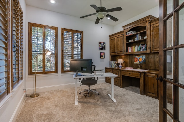 carpeted office featuring ceiling fan