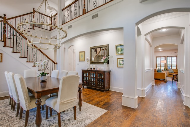 dining space featuring crown molding, dark hardwood / wood-style flooring, and a chandelier