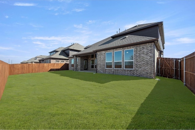 rear view of property featuring a lawn