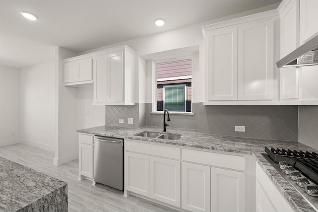 kitchen with sink, white cabinetry, appliances with stainless steel finishes, light stone countertops, and backsplash