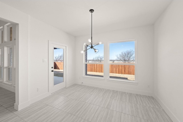 unfurnished dining area featuring an inviting chandelier and a wealth of natural light