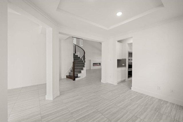 interior space with crown molding and a raised ceiling