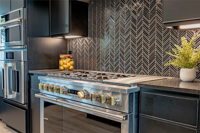 kitchen featuring high end stove and backsplash