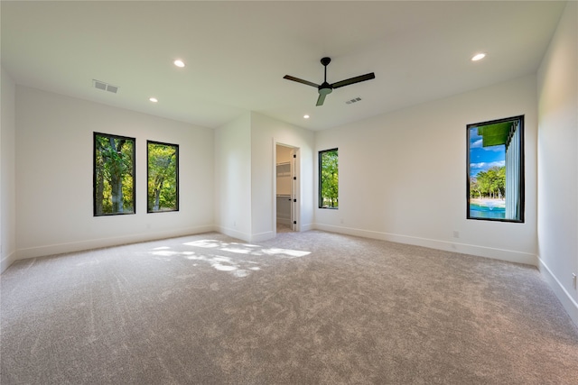 spare room featuring light carpet and ceiling fan