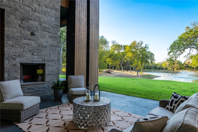 view of patio / terrace featuring an outdoor brick fireplace and a water view