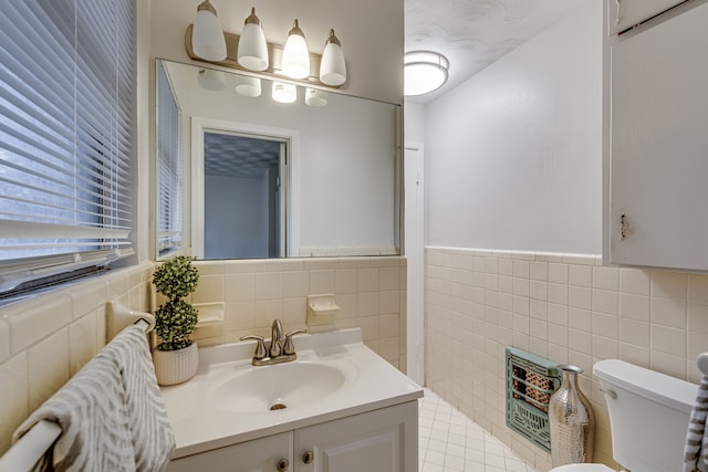 bathroom featuring vanity, tile walls, and toilet