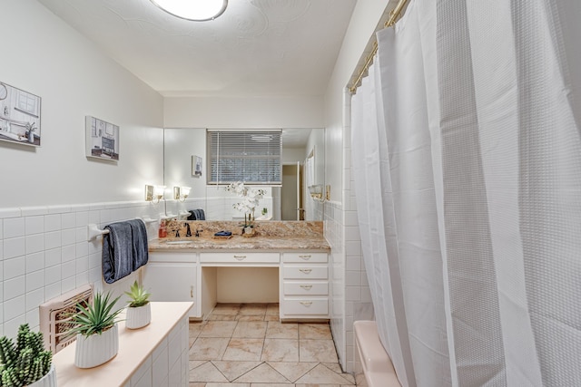 bathroom with vanity, plus walk in shower, tile patterned flooring, and tile walls