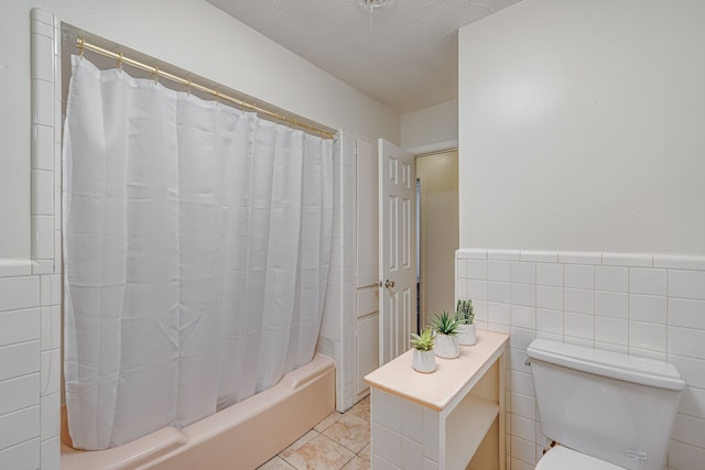 full bathroom with tile walls, shower / bathtub combination with curtain, vanity, tile patterned flooring, and toilet