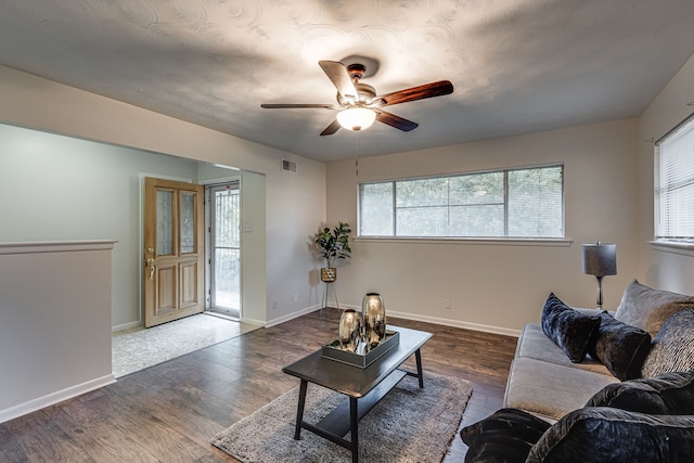 living room with dark hardwood / wood-style flooring and ceiling fan