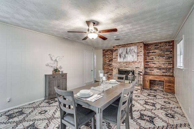 dining room with a fireplace, wood walls, and ceiling fan