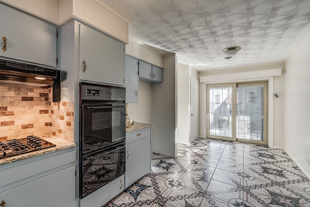 kitchen featuring exhaust hood, backsplash, black oven, and light stone counters