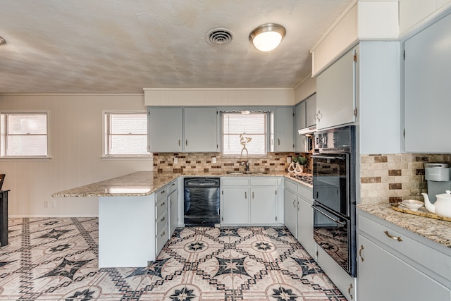 kitchen featuring backsplash, kitchen peninsula, light stone countertops, a textured ceiling, and black double oven