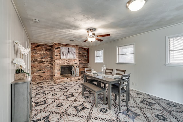 dining area featuring a healthy amount of sunlight, ceiling fan, and a brick fireplace