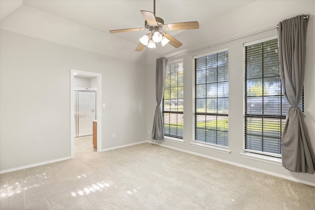 unfurnished room with light carpet, ceiling fan, and vaulted ceiling