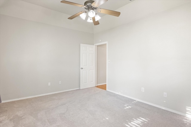 unfurnished room featuring ceiling fan, light carpet, and a high ceiling