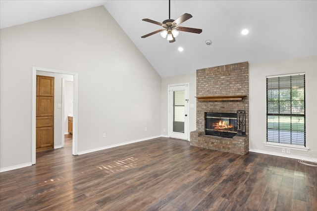 unfurnished living room with high vaulted ceiling, ceiling fan, dark wood-type flooring, and a brick fireplace