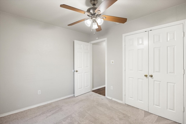 unfurnished bedroom with ceiling fan, light colored carpet, and a closet